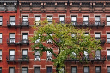 Old New York apartment building with ornate moldings front fire escape