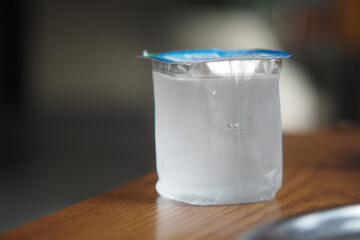 Water-filled container resting on a wooden table in a cozy setting
