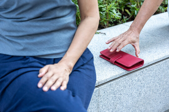 Old woman about to be pickpocketed, leaving her purse unattended and being stolen, concept Image of Urban crime, pick pocketing, petty criminal, caution beware of pickpocketeer