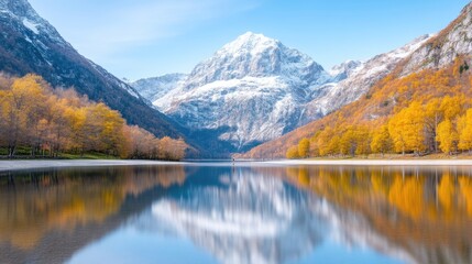 Fototapeta premium Serene autumnal lake nestled amidst majestic mountains, showcasing vibrant fall foliage reflected in calm waters. Snow-capped peaks dominate the background