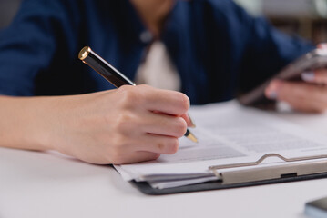 person signing document with pen, holding smartphone, Writing contract law and paper work for business and finance, write document, job application forms, contract real estate and insurance concept.