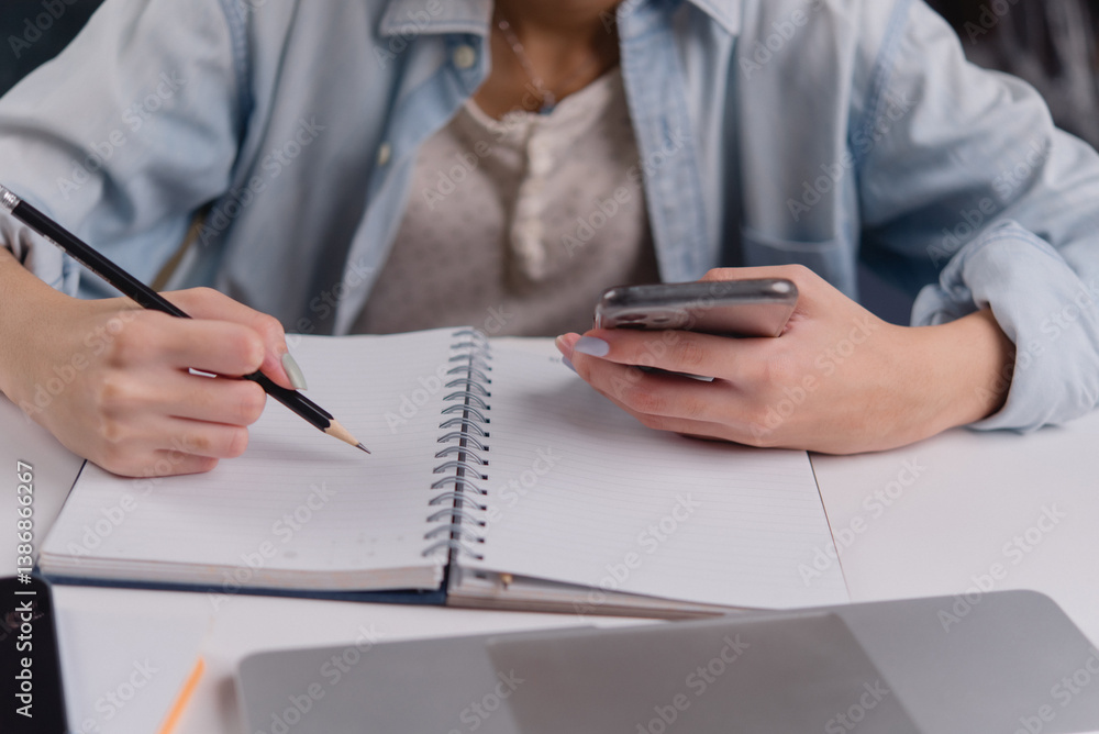 Poster young woman using a smartphone while taking notes, showcasing the balance between digital communicat