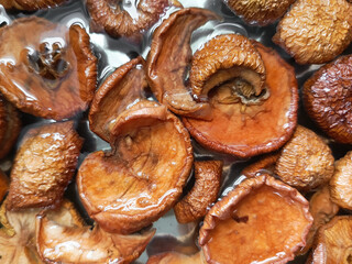 Dried fruits in water in a cup. Washing and soaking dried fruits. Dried apples. Cooking homemade compote. 