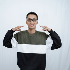 A young Asian man with glasses wearing a sweater is pointing to himself. Isolated on white background.