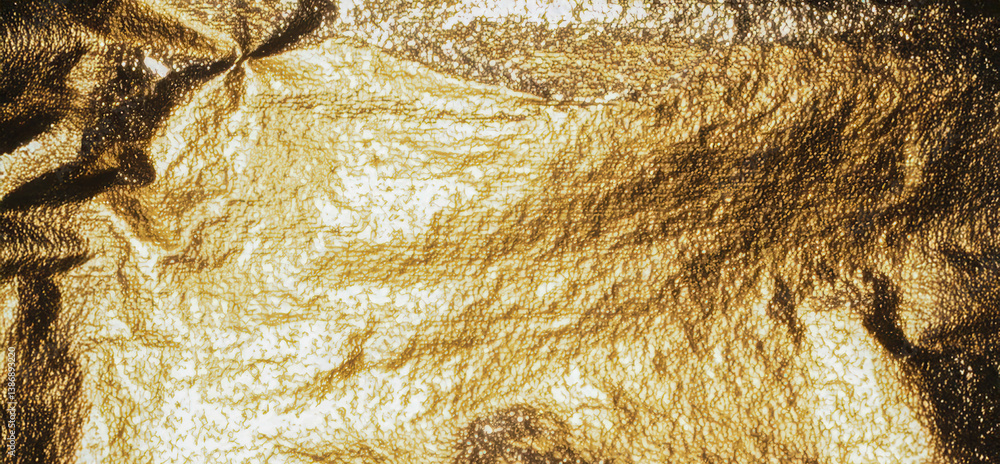 Poster gold foil background with grainy texture and metallic sheen. crumpled surface with shiny, reflective