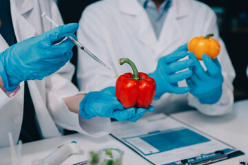 Team Asian scientists in a lab conducting food research using a microscope and lab equipment,...