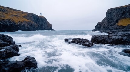 Obraz premium Dramatic coastal scene with waves crashing against rocks, a lighthouse on a cliff in the background