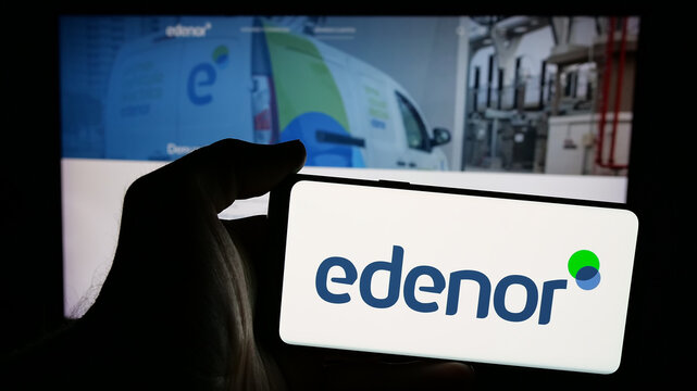 Stuttgart, Germany - 03-27-2025: Person holding mobile phone with logo of Argentinian energy company Edenor S.A. on screen in front of web page. Focus on phone display.