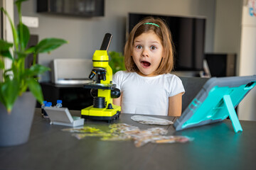 Child amazed reaction after seeing something for the first time under a microscope. Concept of scientific discovery and the joy of learning