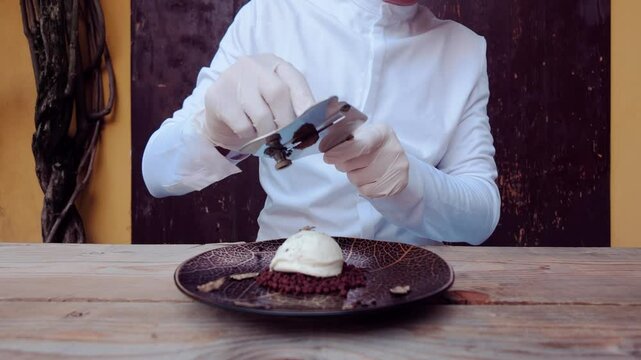 Chef slices black truffle over ice cream