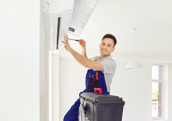 Portrait of a happy and smiling man professional electrician or technician inspecting and fixing a home air conditioner suing tools, ensuring optimal performance and comfort in the household.
