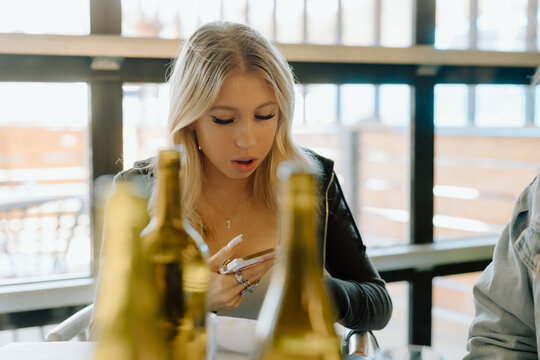 Gen Z girl checking her phone at a restaurant