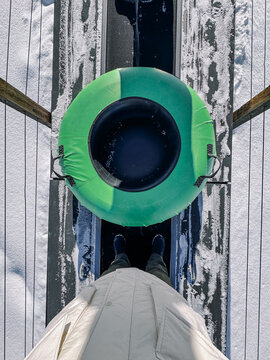 POV of person with snow tube on lift, ready to go tubing in Utah