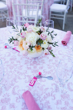 Tennis-themed table with floral centerpiece and pink "LOVE" favors