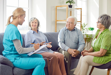Caregiver conducting a medical checkup or consultation for a group of positive senior patients at a...