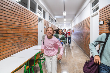 Cheerful students running in school hallway after the bell rings, excited for the end of classes