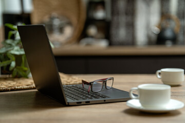 Working at a cozy desk with laptop and coffee during the morning