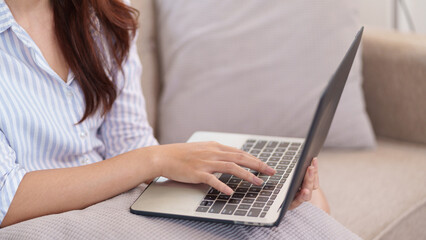 Digital Work in Living Room: The image captures a person engrossed in their laptop, nestled on a...