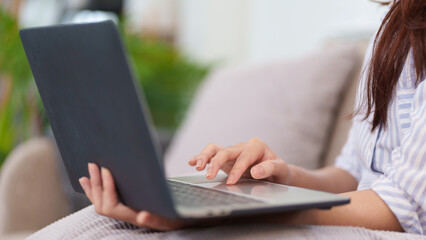 Digital Engagement: A person is deeply engrossed in their laptop, tapping on the touchpad,...