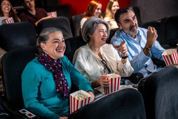 Group of people enjoying a movie and eating popcorn in a cinema