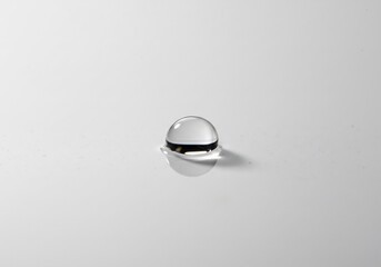 透明な水滴、柔らかな光で輝く白い背景