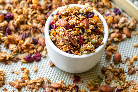 Bowl of Healthy Roasted Granola on a sheet pan