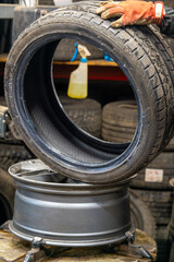 Automotive Tire Replacement Service with Professional Tire Mounting Machine in Garage Workshop. Mechanic Hands Operating Specialized Equipment for Seasonal Tire Change Process