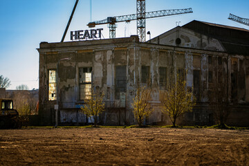 Old factory with a tall chimney. A dilapidated building in a former industrial zone in the city of...