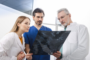 Doctors examining cerebrovascular MRI image of brain during a medical consultation for patient with...