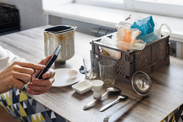 Closeup of man reading recipe on smartphone for making bread at home. Bread preparation at home, checking recipe on smartphone, ingredients ready to bake