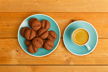 Homemade coffee-chocolate cookies and cup of coffee espresso on wooden table. Top view.
