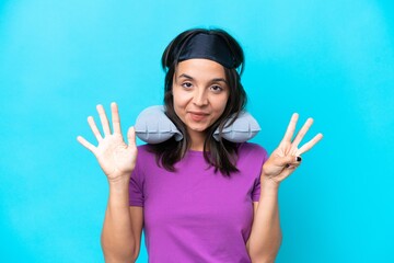 Fototapeta premium Young caucasian woman with Inflatable Travel Pillow isolated on blue background counting eight with fingers