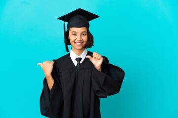 Young university graduate girl over isolated blue background pointing to the side to present a...