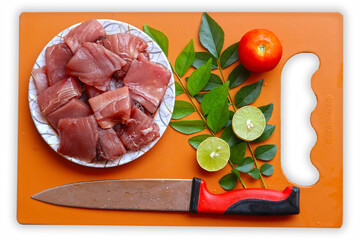 fresh fish fillet in plate  with curry leaf lemon tomato and knife on cutting board