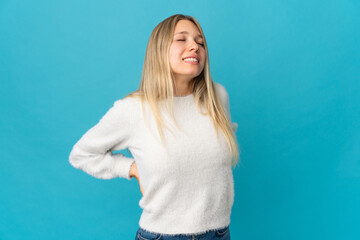 Young blonde woman isolated on blue background suffering from backache for having made an effort