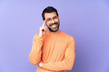 Caucasian handsome man over isolated purple background with glasses and happy