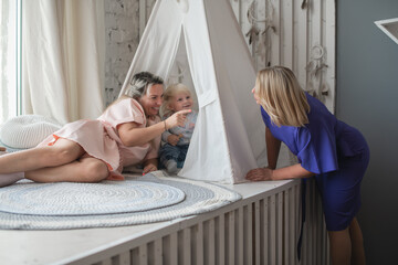 Happy mother, child and grandmother have fun at home. Smile, happiness and parental care in the house with love and closeness to the child.