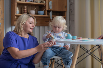 Grandmother with grandson boy at home. Relatives bonding and generational communication. Old lady and child having fun together.