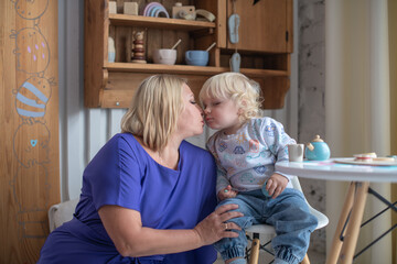 Grandmother with grandson boy at home. Relatives bonding and generational communication. Old lady and child having fun together.