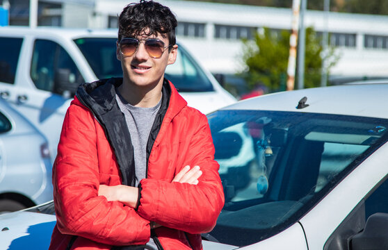 Fototapeta handsome young man with sunglasses with arms crossed on the street