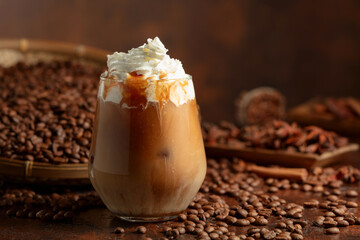 Iced caramel latte topped with whipped cream and caramel sauce.