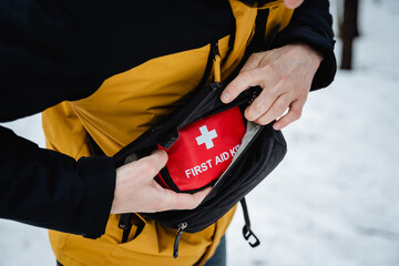 A person is conveniently holding a first aid kit securely tucked away in their pocket, ensuring they are prepared for any unexpected situation that may arise during their day