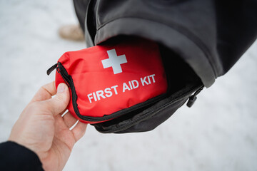 A responsible person is carefully holding a first aid kit in their hand, fully prepared to assist...