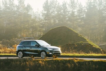 Fototapeta premium Gray car driving through landscape