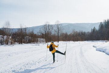 A person is actively engaged in the activity of cross country skiing on a snowy road that is...