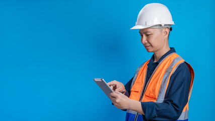 Fototapeta premium Confident young engineer wearing orange and a safety helmet stands holding a laptop, phone with various emotions.