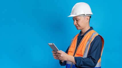 Confident young engineer wearing orange and a safety helmet stands holding a laptop, phone with various emotions.