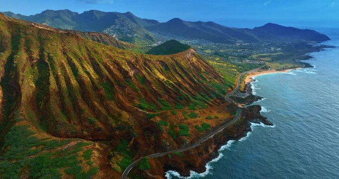 Breathtaking scenery of the mountainous shore of the Island Oahu, Hawaii, USA. Long highway stretches along the coast. Aerial perspective.