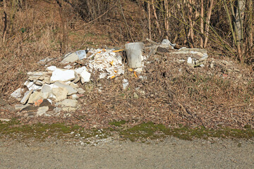 Large household waste and garbage, lying in the green area by the road. Environmental pollution and...