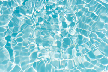 Blue water with ripples on the surface. Defocus blurred transparent blue colored clear calm water surface texture with splashes and bubbles. Water waves with shining pattern texture background.